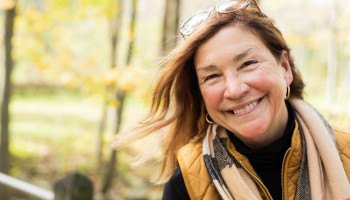 a woman standing outside and smiling